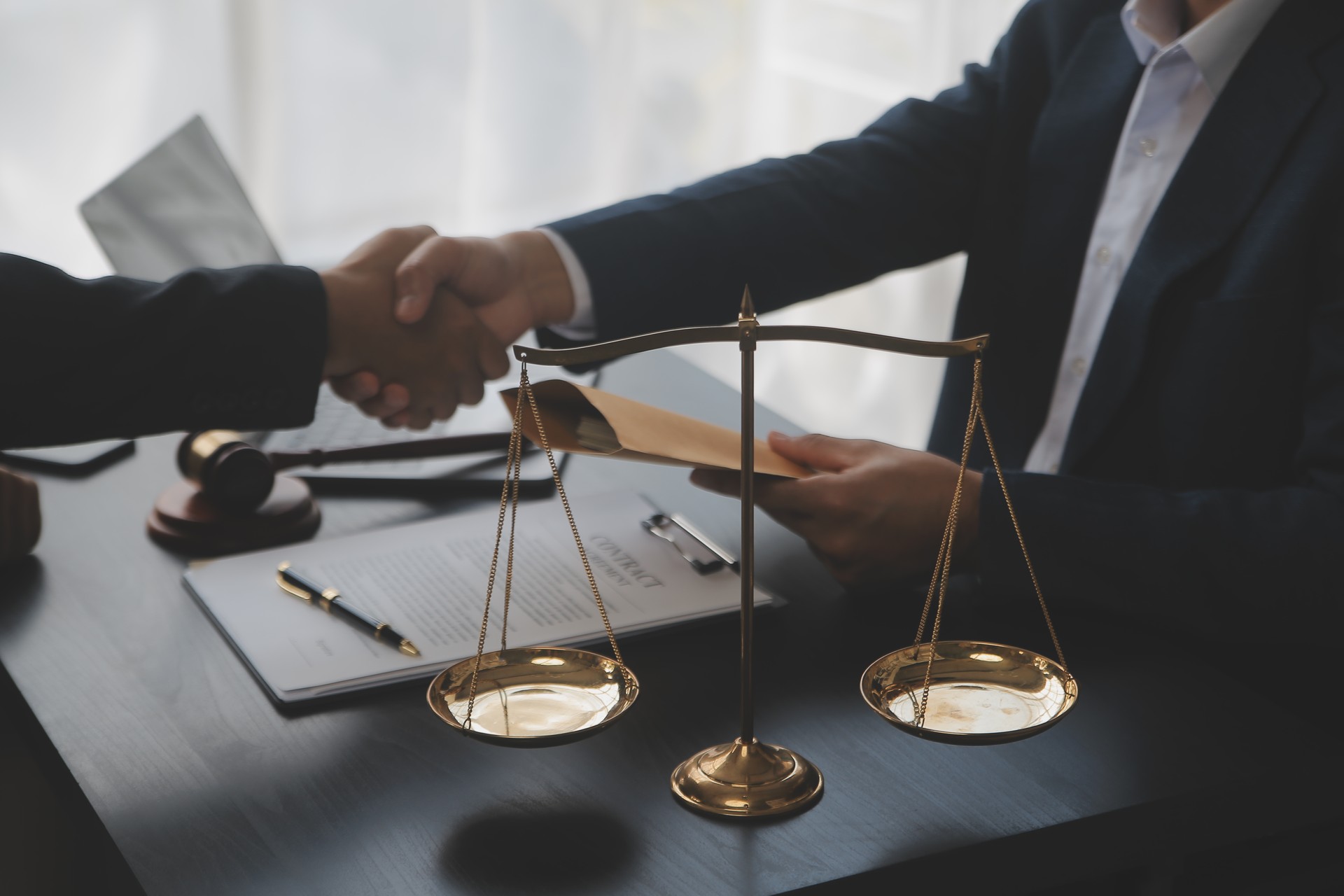 Business and lawyers discussing contract papers with brass scale on desk in office. Law, legal services, advice, justice and law concept picture with film grain effect